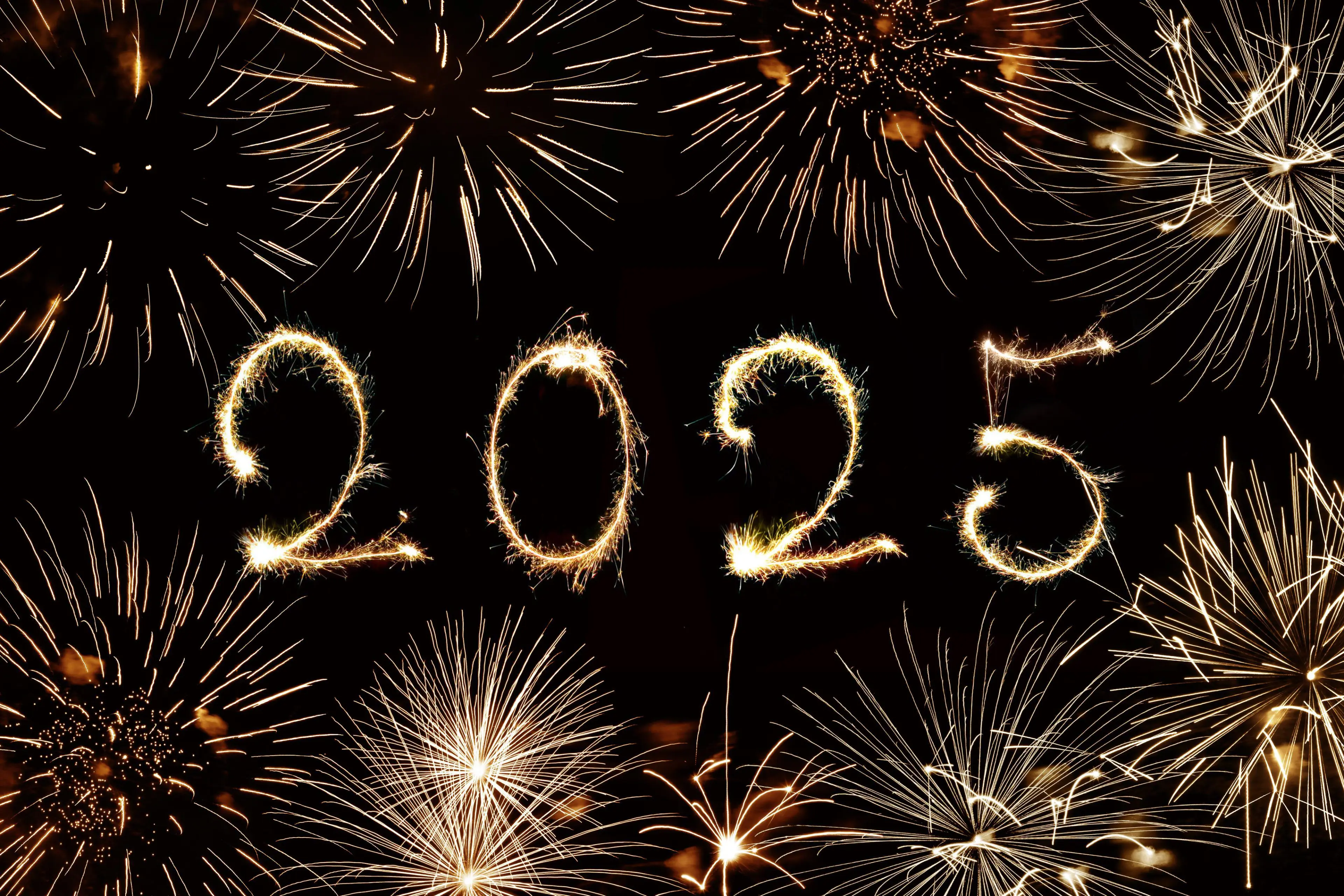 2025 written with sparkles and fireworks