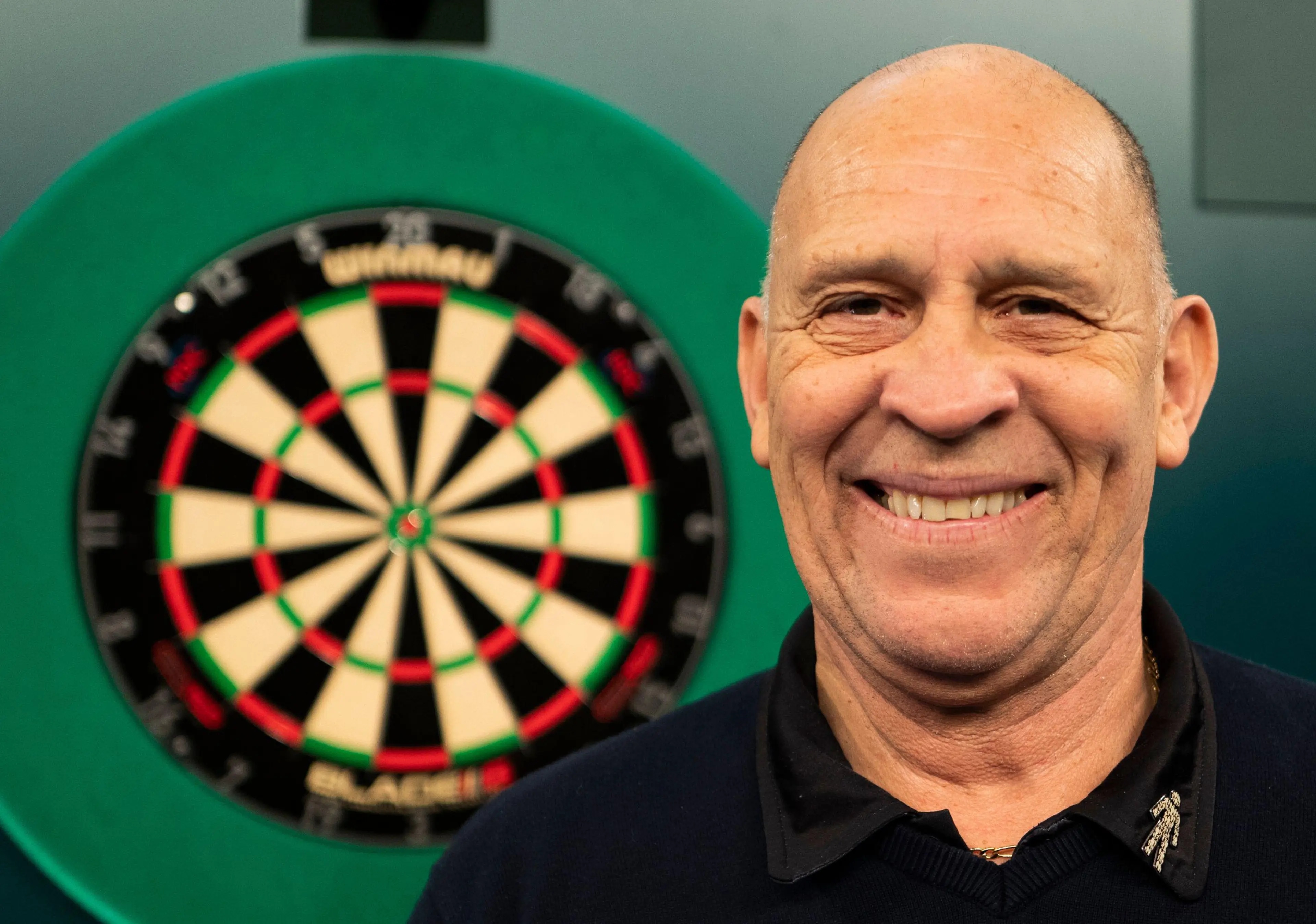 Russ Bray poses for photos on day six of the Paddy Power World Darts Championship