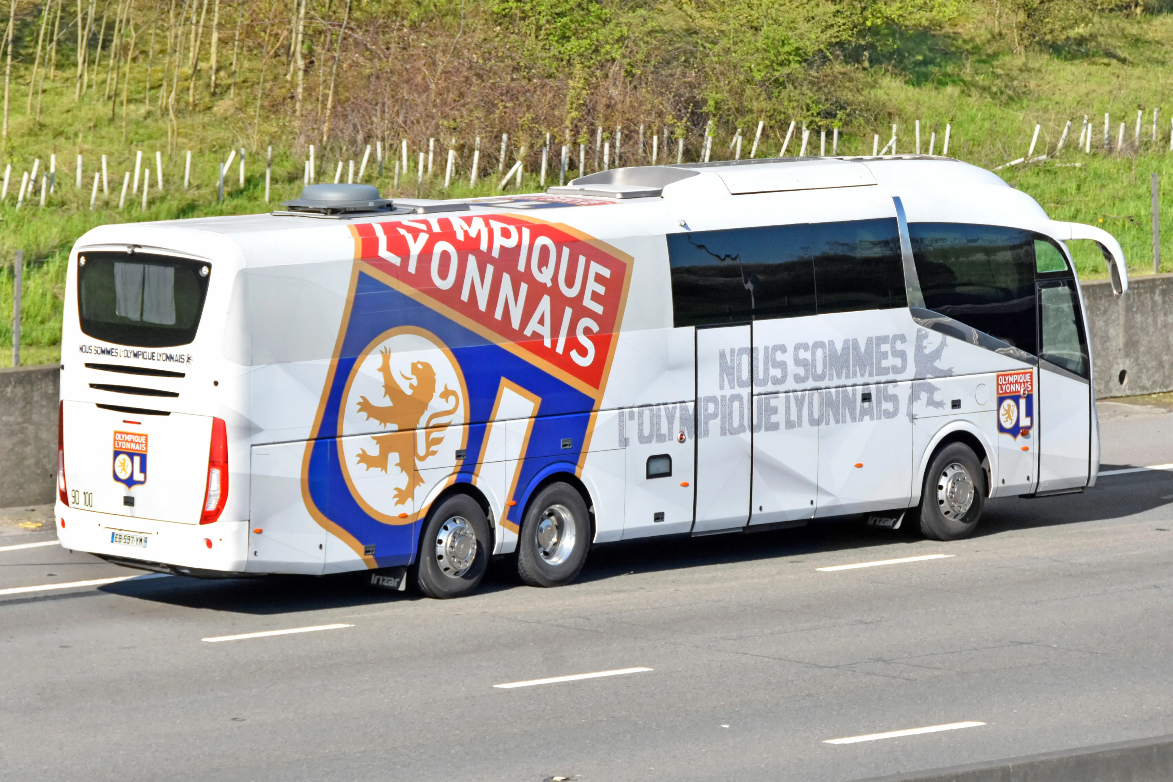 Bus transport for Olympique Lyonnais French football club based in Lyon France with logo on team coach seen driving along M25 UK motorway England UK