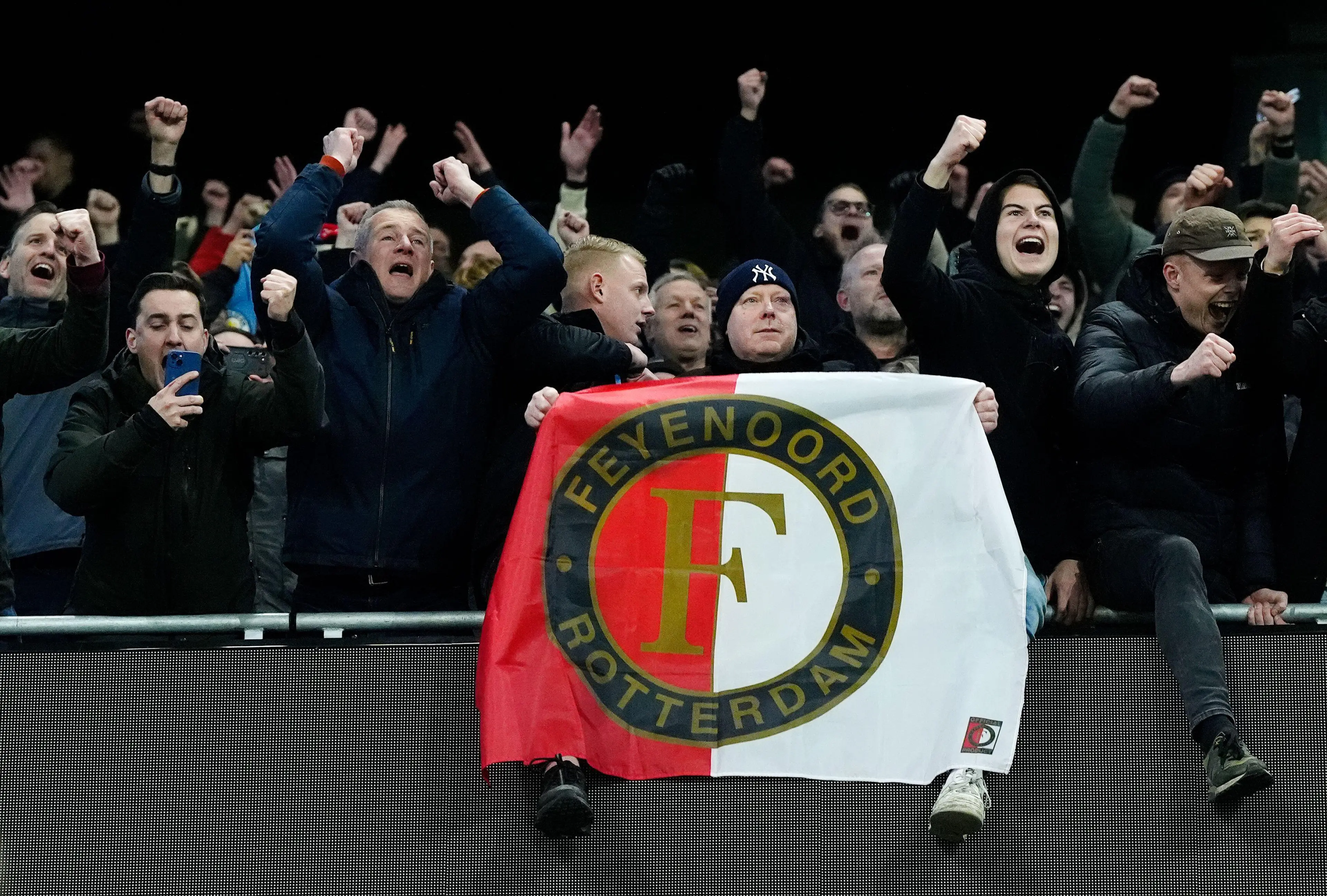 A Feyenoord fan holding a flag with the club badge during the UEFA Champions League