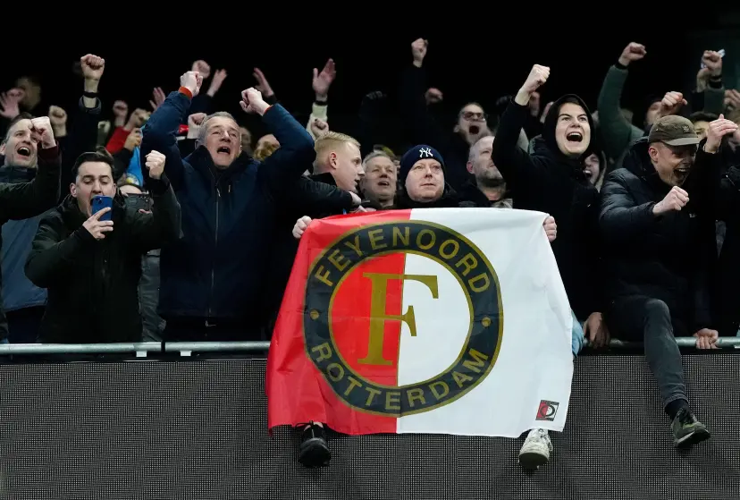 A Feyenoord fan holding a flag with the club badge during the UEFA Champions League