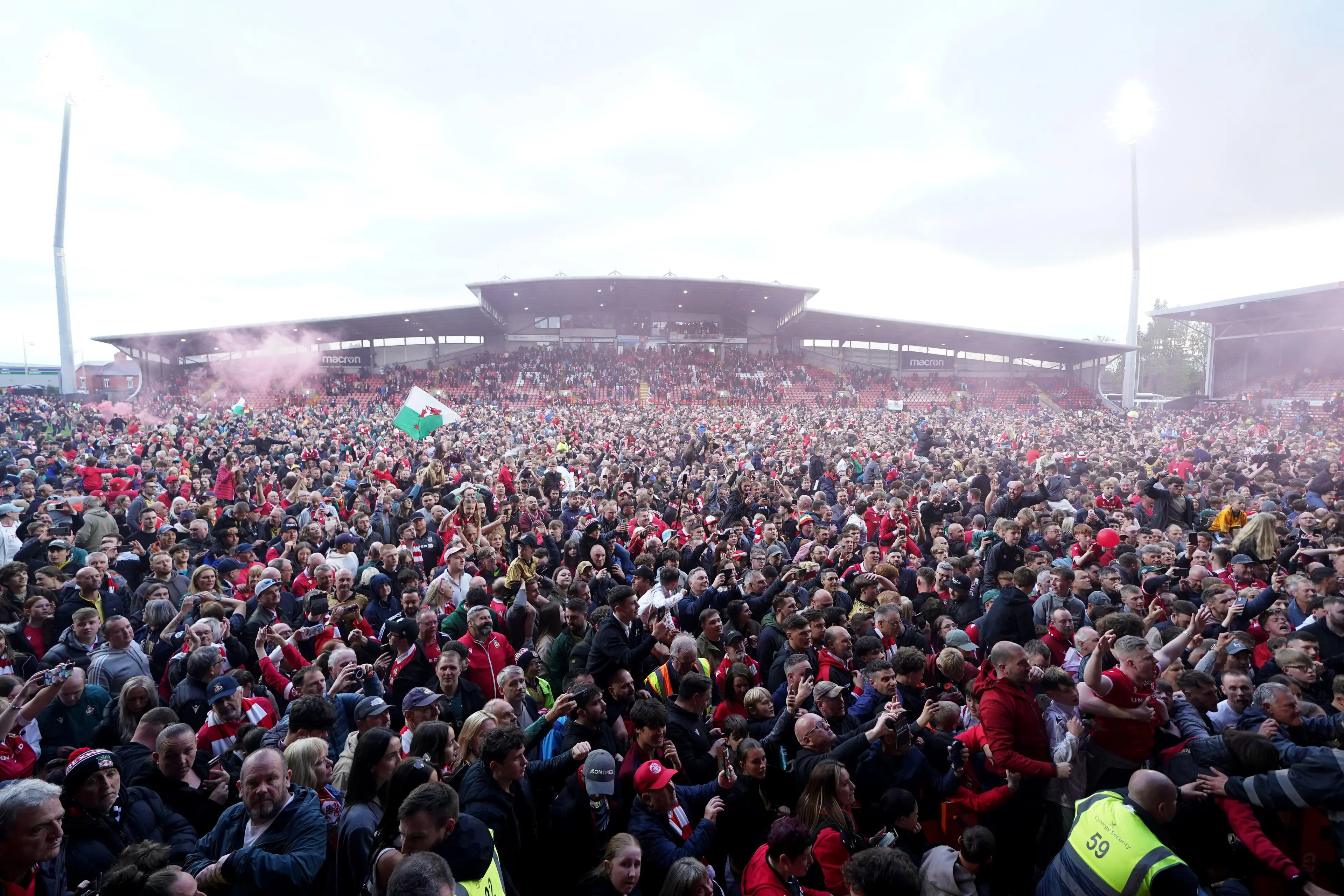 Wrexham's fans on the pitch after Wrexham won promotion to the Sky Bet Championship after the Sky Bet League One match at SToK Racecourse, Wrexham. Picture date: Saturday April 26, 2025