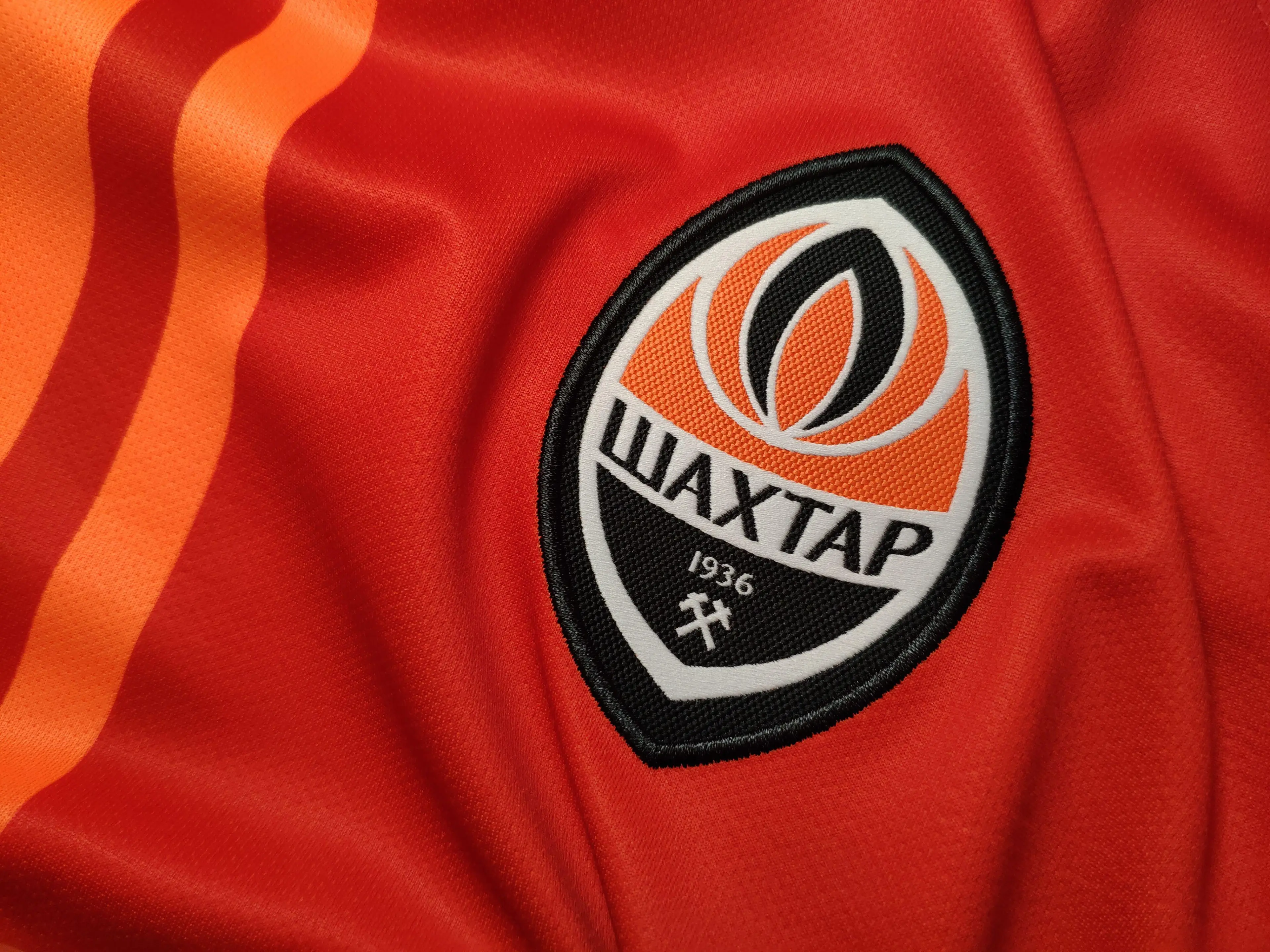 FC Shakhtar Donetsk emblem on the orange home jersey background
